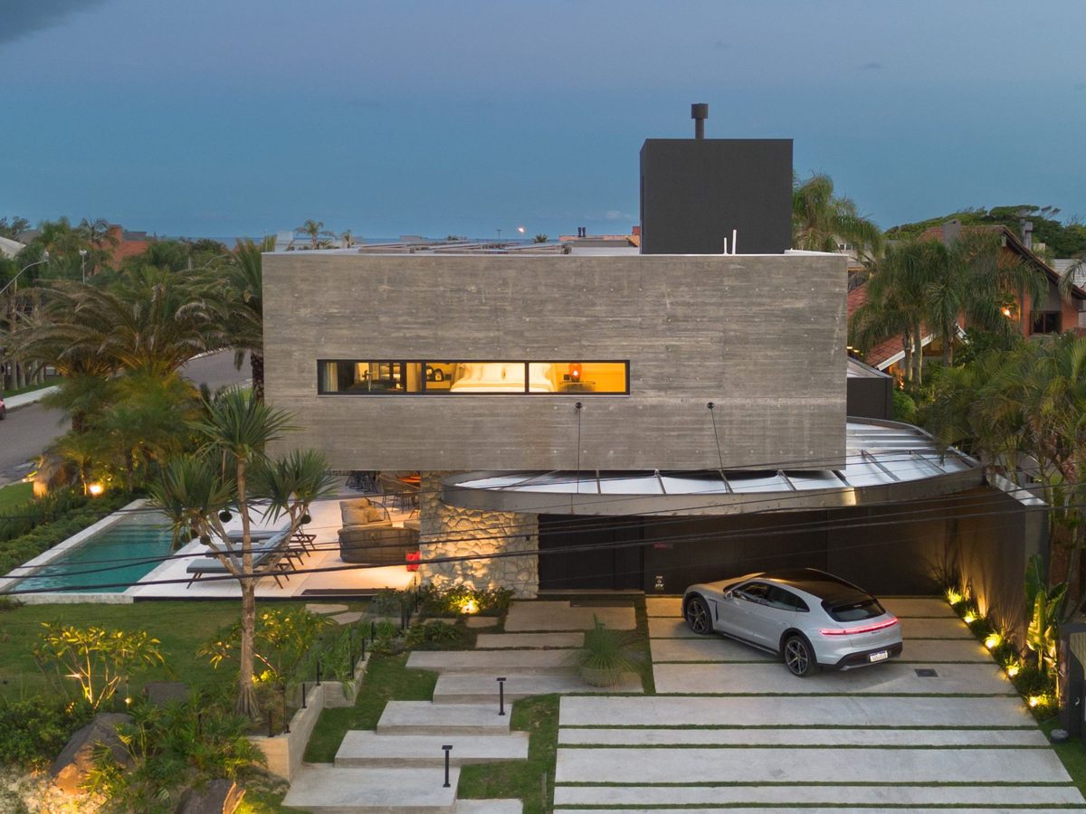 Fachada de mansão com piscina ao entardecer, no bairro Atlântida, em Xangri-lá