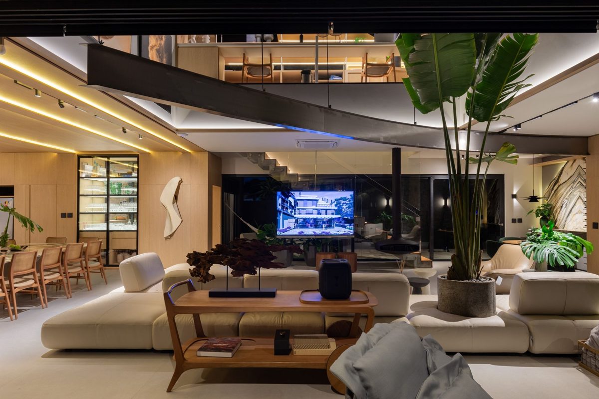 Sala de estar ampla com tela e acabamentos em madeira clara, em mansão em Atlântida, Xangri-lá