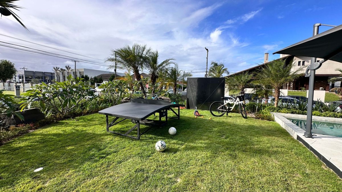 Gramado com mesa de pingue-pongue e jardim, em mansão em Atlântida, Xangri-lá