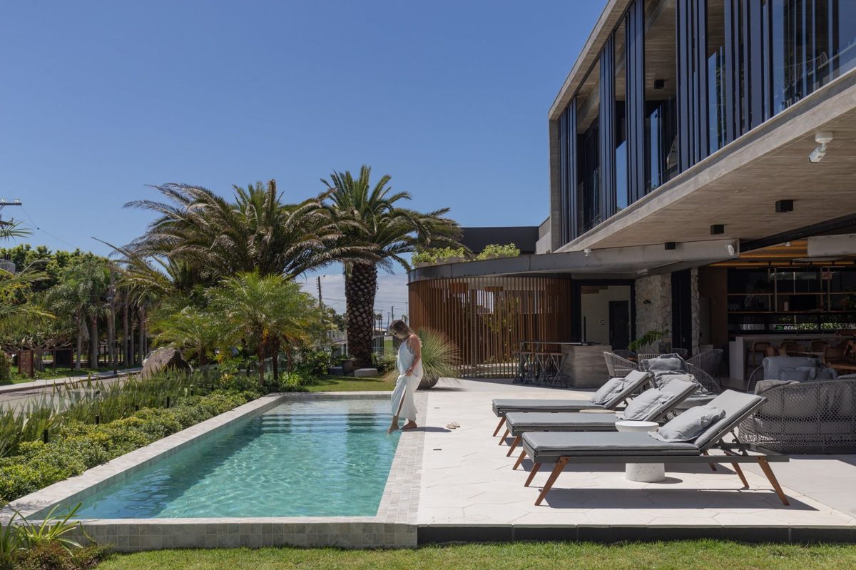Piscina externa com espreguiçadeiras e jardim, em mansão em Atlântida, Xangri-lá